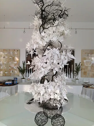 Indoor event venue decorated with an elaborate white paper-crane sculpture installation