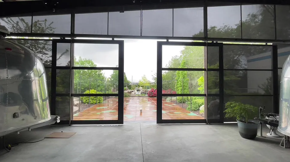 Venue interior looking out through glass garage doors to the patio and garden